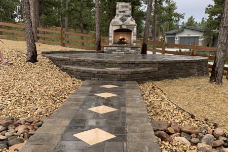 Clik to view full size Segmental retaining wall holding up a paver patio for the gas fired fireplace in Monument Colorado
