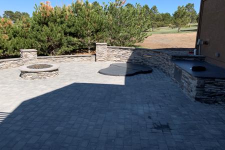 Clik to view full size Monument, Colorado paver patio with a granite slab for serving and a veneer sitting wall for entertainment, built around an in ground hot tub