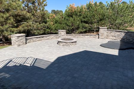 Clik to view full size Veneer stoned fire-pit and sitting wall for this back yard in Monument, Colorado to go along with the paver patio