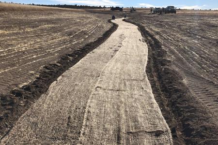 Clik to view full size Installed special erosion control blanket in a large ditch in Black Forest, Colorado to slow down the erosion and get grass to grow
