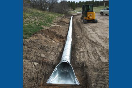 Installing a new series of culverts to divert the water way from the barn in Larkspur, Colorado