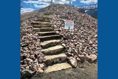 Landscape in Palmer Lake, Colorado for the bridge system that goes over the rail road tracks. These stairs lead you down to the lower trail system. The installation of Siloam Stone stairs and landscape rock.