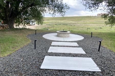 Landscaping Black Forest, Colorado. Installed a wood burning fire pit with Veneer stone, landscape stone and lighting around it for beautiful evenings under the stars