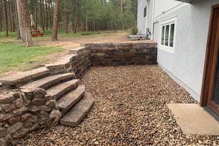 Click to view full size Retaining wall in Monument, Colorado. This segmental retaining wall was to create more usable space in the back yard as well as allow access with the integrated segmental stairs