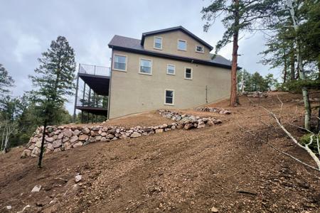Retaining wall in Florissant, Colorado. Installed a series of boulder retaining walls to divert the water away from the foundation and establish erosion control.