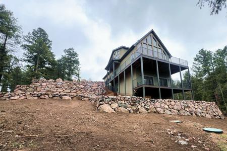 Retaining wall in Florissant, Colorado. Installed a series of boulder walls to create an entrance into the garage of this new home build. The lower boulder retaining walls were built to create a patio as well as level off the area behind the deck to protect the deck pillars.