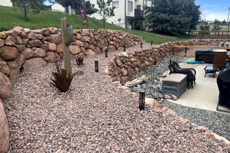 Retaining wall Monument, Colorado. Installed a boulder retaining wall in Monument, Colorado to keep the dirt and water away from the back yard and to divert the water to where we wanted for erosion control.