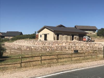 Click to view full size Boulder retaining wall in Castle Rock Colorado for a horse barn